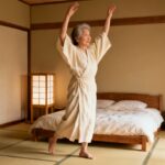 Gentle elderly woman doing morning stretching in traditional Japanese bedroom, promoting flexibility and wellness, ideal for seniors and adults seeking daily stretching routines for health and relaxation.