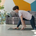 1. Woman practicing stretching exercise in living room, focusing on flexibility and mobility, on yoga mat, home workout, indoor stretching, relaxing at home.