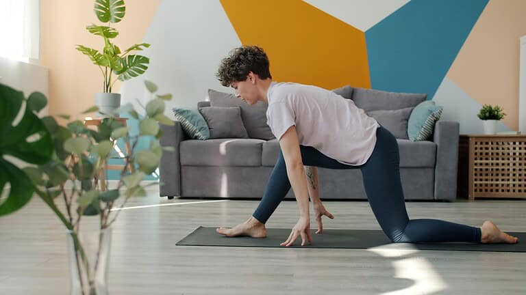 1. Woman practicing stretching exercise in living room, focusing on flexibility and mobility, on yoga mat, home workout, indoor stretching, relaxing at home.